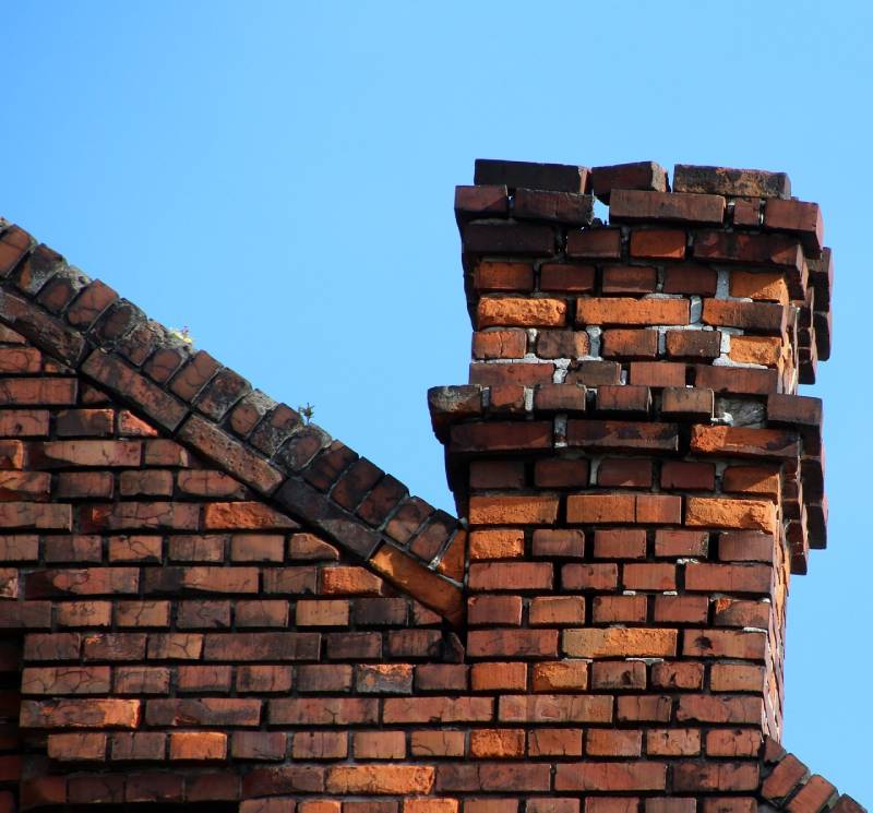 Damaged chimney on an Coral Gables home showing cracks and missing mortar